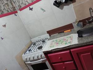 cocina con fogones blancos y fregadero en Cabaña hospedaje mis nietas AJB en Las Compuertas