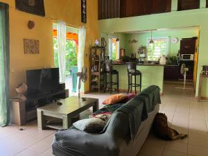 uma sala de estar com um sofá e uma mesa em Kazamwe em Petit-Bourg