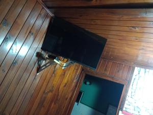 TV de pantalla plana colgada de un techo de madera en Cabaña hospedaje mis nietas AJB en Las Compuertas