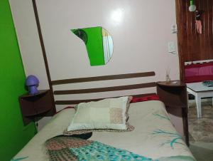 Un dormitorio con una cama con una pared verde y blanca en Cabaña hospedaje mis nietas AJB en Las Compuertas