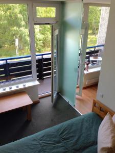 1 dormitorio con 1 cama y 2 ventanas grandes en Amber Loft, en Nida