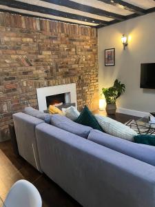 niebieską kanapę w salonie z kominkiem w obiekcie Stylish Apartment in CENTRAL LONDON w Londynie