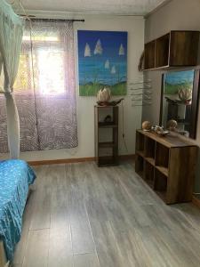 um quarto com uma cama, uma mesa e uma janela em Kazamwe em Petit-Bourg
