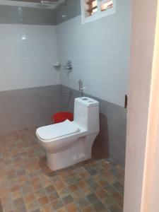 a bathroom with a white toilet in a room at River View Guest Rooms in Vythiri