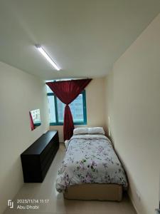 Bedroom 4 في أبوظبي: غرفة نوم بسرير وستارة حمراء