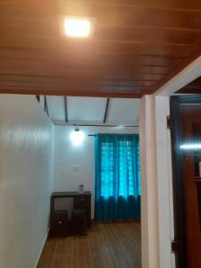 a living room with a blue curtain and a table at River View Guest Rooms in Vythiri