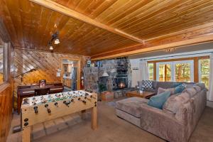 a living room with a game table in front of a fireplace at 050 - The Great Escape - Meredith Lodging in Big Bear City