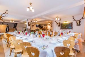 a long table in a room with white tables and chairs at Pod Modrzewiami in Zakopane