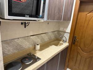 a small kitchen with a sink and a microwave at Ammash Services and Hotel Rooms in Jeddah