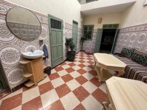 a bathroom with a sink and a checkered floor at Happy Marrakchy in Marrakesh