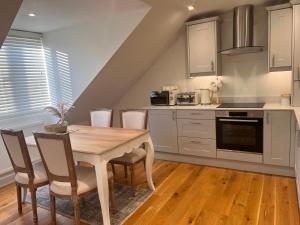 a kitchen with a wooden table and chairs at Abingdon in Sunningwell