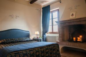 a bedroom with a blue bed and a fireplace at Agriturismo Locanda Pantanello in Pitigliano