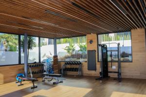 een fitnessruimte met cardio-apparatuur in een kamer met ramen bij 3-bedroom penthouse with private roof terrace and fantastic view in Orihuela