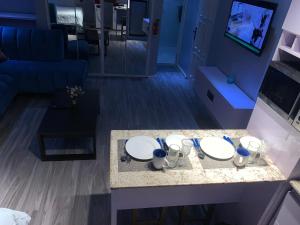 a table in a living room with two white plates at Teal Snug Open-Plan Studio Unit in Lekki Phase 1-Netflix, Wi-Fi, 24-7 Light, Washer, Kitchen in Lagos
