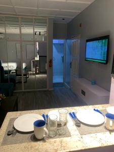 a dining table with two white plates on top of it at Teal Snug Open-Plan Studio Unit in Lekki Phase 1-Netflix, Wi-Fi, 24-7 Light, Washer, Kitchen in Lagos