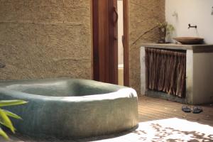 a bath tub in a room with a fireplace at Pousada Spa Oasis in Caraíva