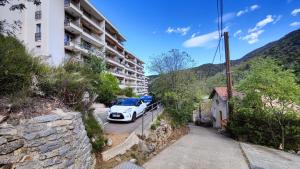 a white car parked on a street next to a building at Mon petit nid à Amélie in Amélie-les-Bains-Palalda