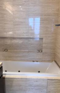 a white bath tub in a bathroom with a tile wall at Burj Khalifa in Dubai