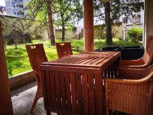 Bel Appartement avec jardin privé au calme في ستراسبورغ: طاولة وكراسي خشبية على شرفة
