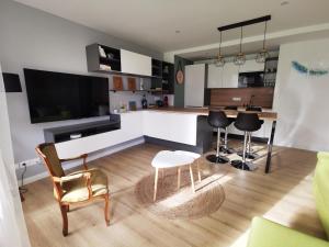 Bel Appartement avec jardin privé au calme في ستراسبورغ: مطبخ وغرفة معيشة مع طاولة وكراسي