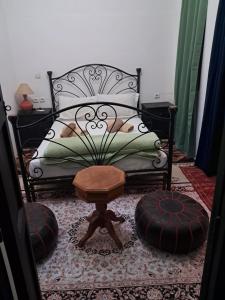 um quarto com uma cama, uma mesa e um banco em Riad Dantella em Marraquexe