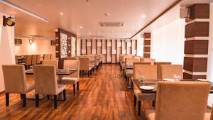una sala da pranzo con tavoli e sedie in un ristorante di Welcome Resorts And Spa 