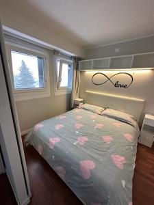 Schlafzimmer mit einem Bett mit rosa Herzen in der Unterkunft Luna Bianca Apartment in Vermiglio