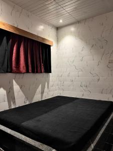 ロナバラにあるMOUNT BUNGALOWS-1 BEDROOM Private pool chalet -wifi -private pool-acの白レンガの壁のベッド1台が備わる客室です。