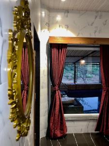 羅納瓦拉的住宿－MOUNT BUNGALOWS-1 BEDROOM Private pool chalet -wifi -private pool-ac，镜子和带红色窗帘的窗户
