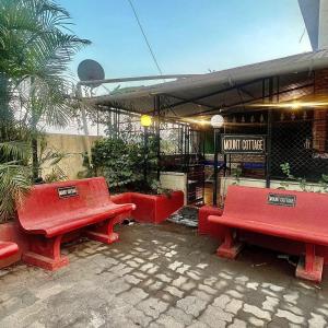 un grupo de bancos rojos frente a un café en MOUNT BUNGALOWS-1 BEDROOM Private pool chalet -wifi -private pool-ac en Lonavala