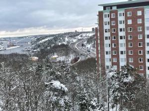 a snow covered city with a building and a road at Room in a private apartment in Nacka