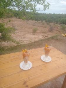 dos bebidas en platos en una mesa de madera en Valle del Cardón, en Villavieja