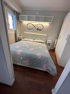 ein Schlafzimmer mit einem Bett mit einem Liebesschild darüber in der Unterkunft Luna Bianca Apartment in Vermiglio