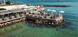a group of people sitting on a dock in the water at Royal Antibes - Luxury Hotel, Résidence, Beach & Spa in Antibes