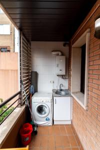 una pequeña cocina con lavadora y fregadero en Comfy Downtown + Private terrace, en Barcelona 30 fotos más