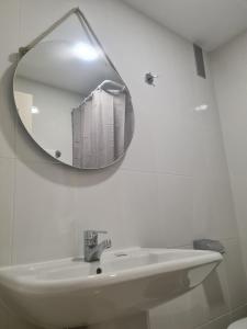 ein Bad mit einem Waschbecken und einem Wandspiegel in der Unterkunft Apartamento Falésia by Garvetur in Albufeira