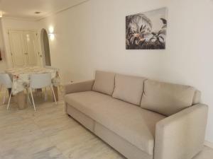 ein Wohnzimmer mit einem Sofa und einem Tisch in der Unterkunft Apartamento Falésia by Garvetur in Albufeira