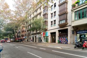 una calle de la ciudad con edificios y una motocicleta estacionada en la calle en Comfy Downtown + Private terrace, en Barcelona