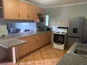 a kitchen with wooden cabinets and a stove top oven at Bougain Villa BnB in Polokwane