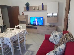 Una sala de estar con un sofá y una mesa con televisión. en Casa frà i Pini, en Imola