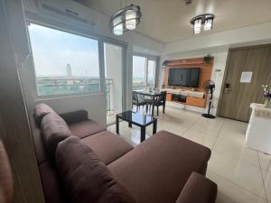 a living room with a couch and a table at De Luxe, Standard and Studio Suites -The Breeze Residences-close to Airport,Mall of Asia, US Embassy in Manila
