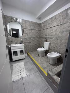 a bathroom with a sink and a toilet and a mirror at Apart Luro III in Santa Rosa +13 photos
