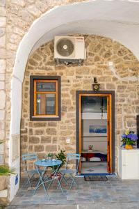 a stone house with a table and chairs and a fan at Da.Ma House a pochi passi dal mare in Meta