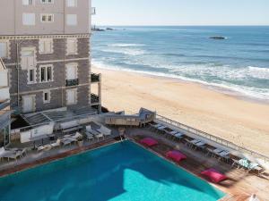 an aerial view of a hotel with a pool and the beach at Sofitel Biarritz Le Miramar Thalassa in Biarritz