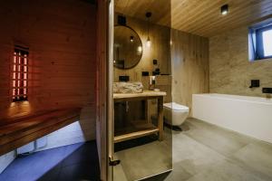 a bathroom with a tub and a toilet and a sink at Luxury Chalet Kajmer in Jurgów