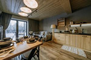 a kitchen and living room with a wooden table at Luxury Chalet Kajmer in Jurgów