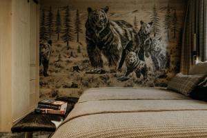 a bedroom with a mural of bears on the wall at Luxury Chalet Kajmer in Jurgów
