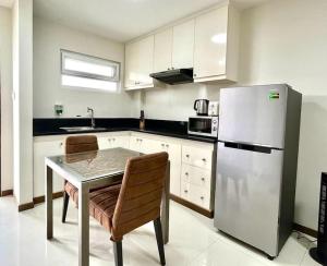 een keuken met een tafel en een roestvrijstalen koelkast bij 203 La Grande, classy studio with hotel amenities! in Angeles