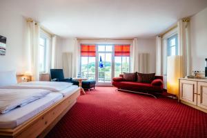 ein Schlafzimmer mit einem großen Bett und einem roten Teppich in der Unterkunft Deutenhof Hotel, Restaurant & Veranstaltung in Bad Abbach