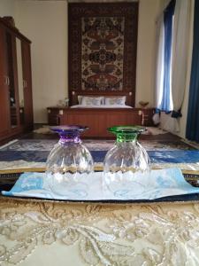 zwei Glasvasen auf einem Tisch im Schlafzimmer in der Unterkunft Ali Ancient House 555 in Şəki